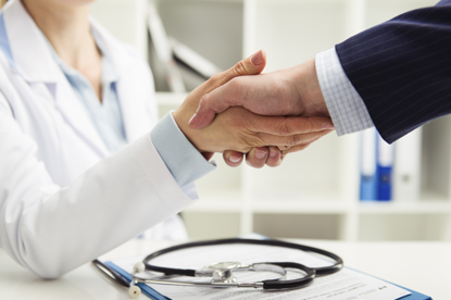 Arts en patient geven elkaar een handdruk
