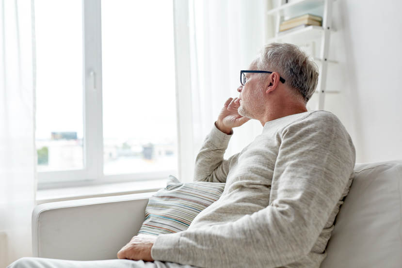 Man op bank kijkt uit het raam